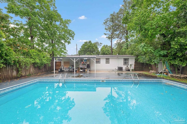 view of pool with a patio and central air condition unit