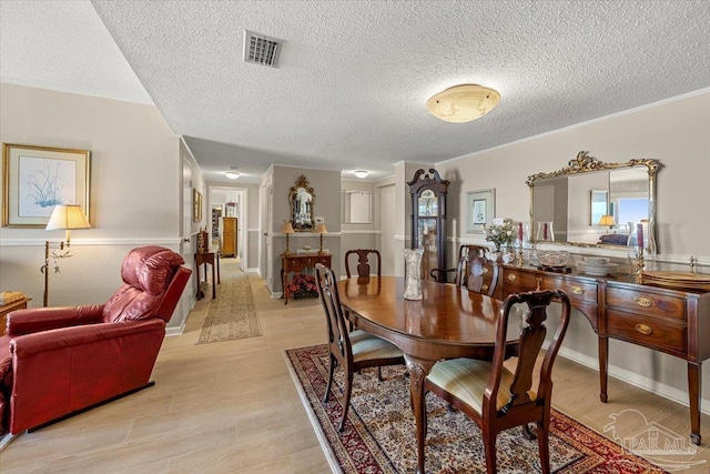 dining room with ornamental molding and a textured ceiling