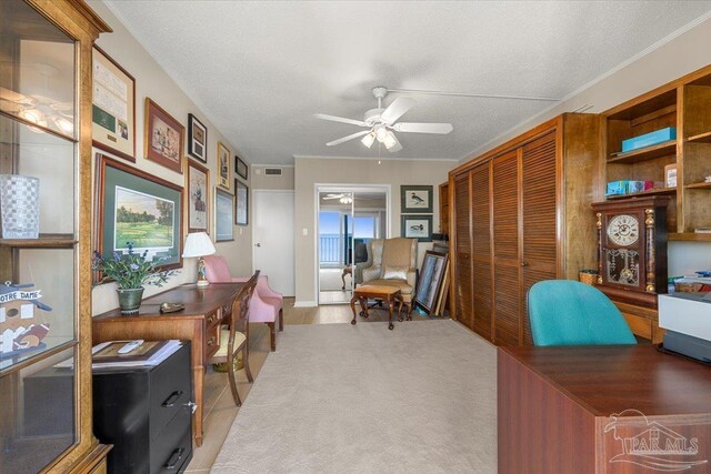 home office with ceiling fan and a textured ceiling