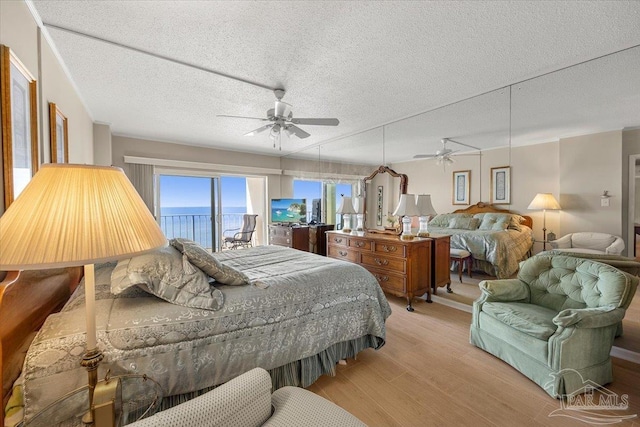 bedroom featuring a textured ceiling, ceiling fan, and light wood-type flooring