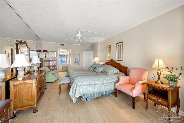 bedroom featuring light hardwood / wood-style flooring, ceiling fan, and a textured ceiling