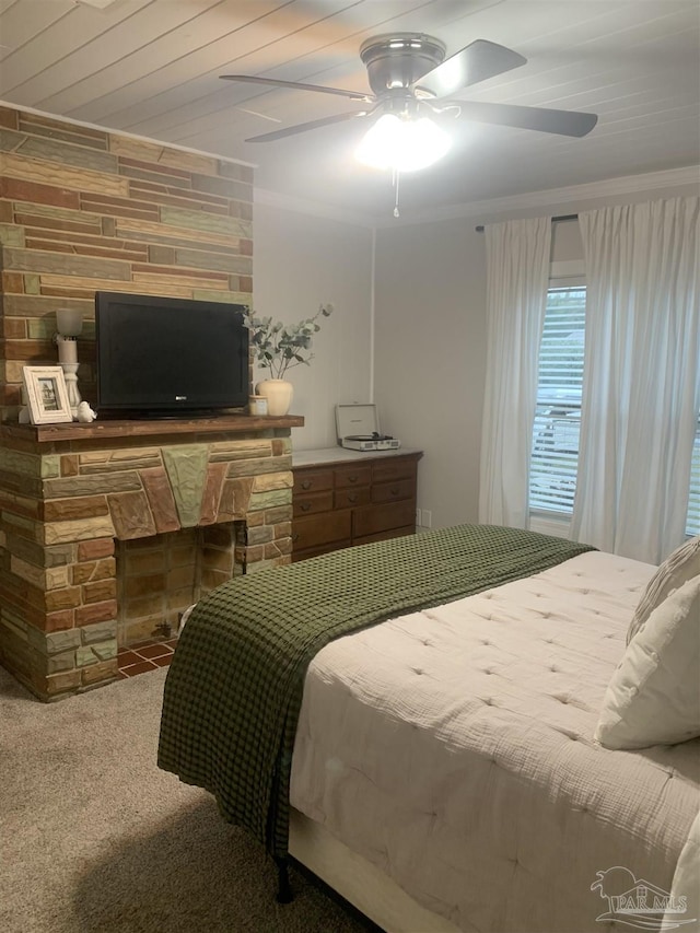 bedroom with carpet flooring, ornamental molding, ceiling fan, a fireplace, and wood walls