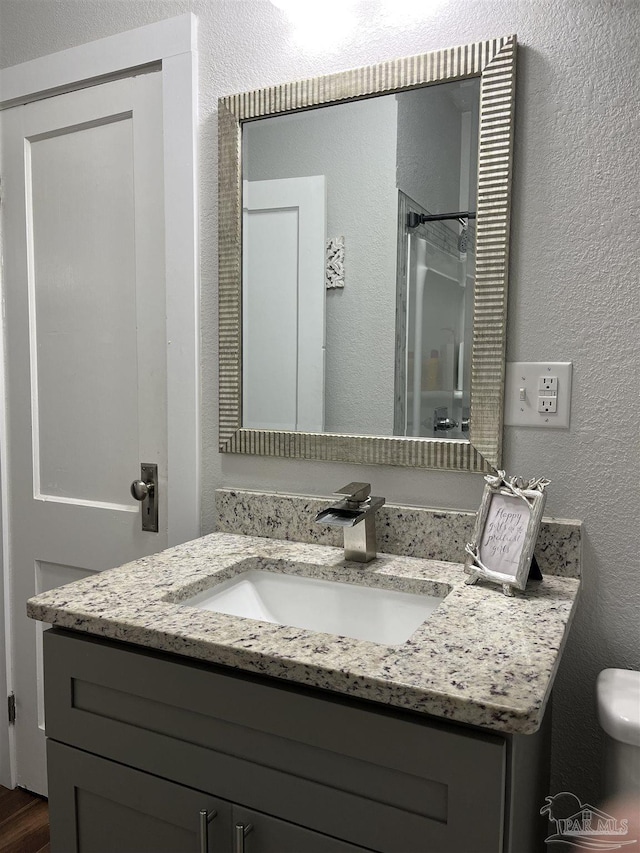 bathroom featuring a shower and vanity