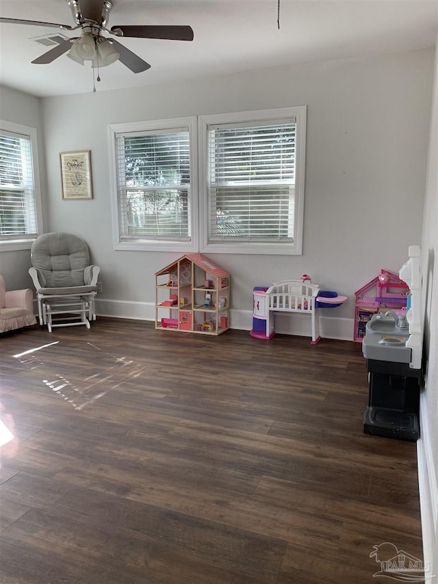 playroom with ceiling fan and dark hardwood / wood-style flooring