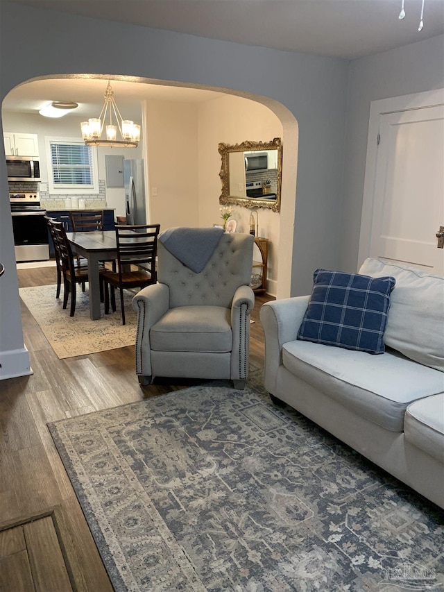 living room with dark wood-type flooring and a notable chandelier