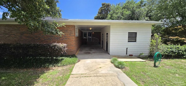 381 Euclid St, Pensacola, FL 32503 - doorway to property with a yard, brick siding, and a carport