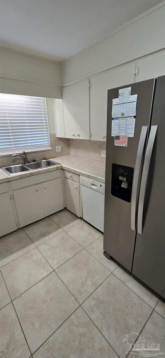 381 Euclid St, Pensacola, FL 32503 - kitchen featuring stainless steel fridge, white cabinets, light tile patterned floors, and dishwasher