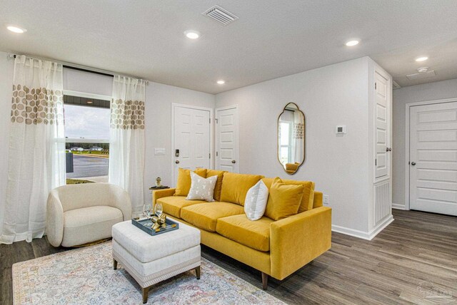 living room featuring dark wood-type flooring and a textured ceiling