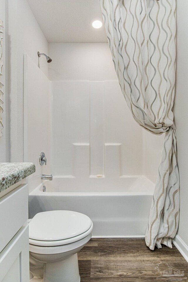 full bathroom featuring wood-type flooring, toilet, shower / tub combo, and vanity