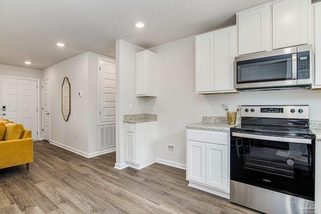 kitchen featuring white cabinetry, appliances with stainless steel finishes, a textured ceiling, and hardwood / wood-style flooring