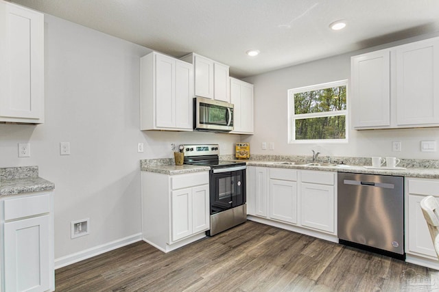 kitchen with dark wood-type flooring, stainless steel appliances, sink, and white cabinets