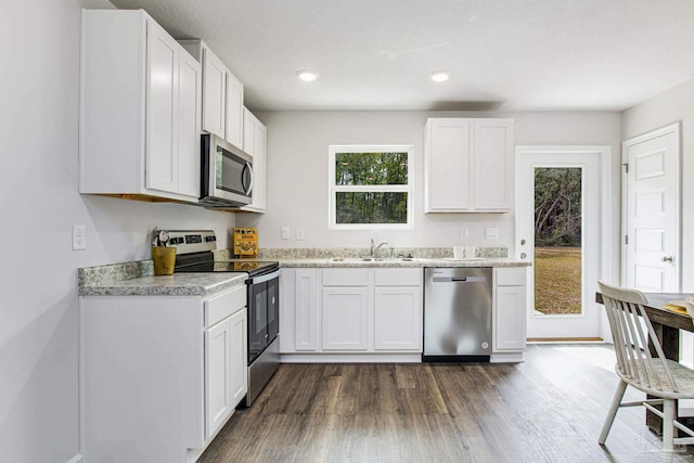 kitchen featuring white cabinetry, sink, dark wood-type flooring, and appliances with stainless steel finishes