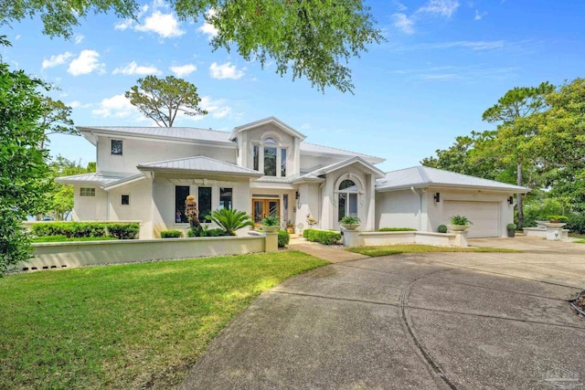 458 Parish Blvd, Mary Esther, FL 32569 - view of front of house featuring a front lawn, stucco siding, a garage, metal roof, and concrete driveway