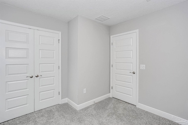 carpeted spare room featuring a textured ceiling