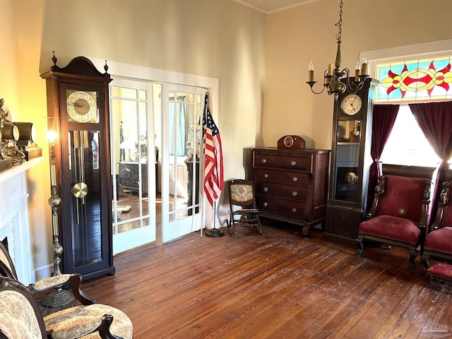 sitting room with an inviting chandelier, ornamental molding, dark hardwood / wood-style floors, and french doors