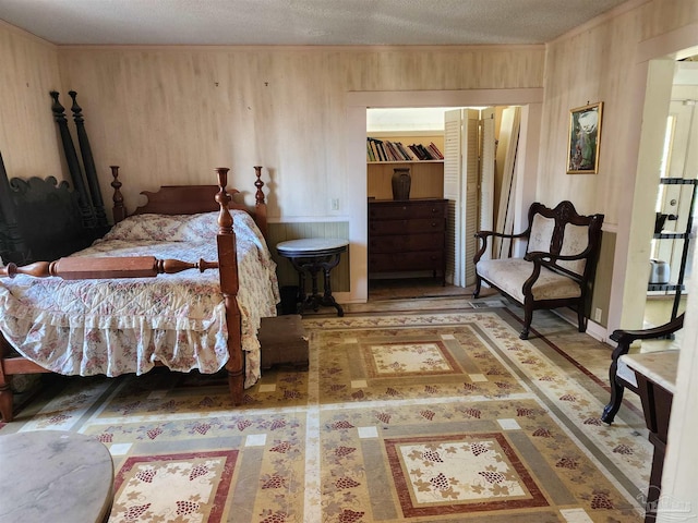 bedroom with wooden walls and a textured ceiling