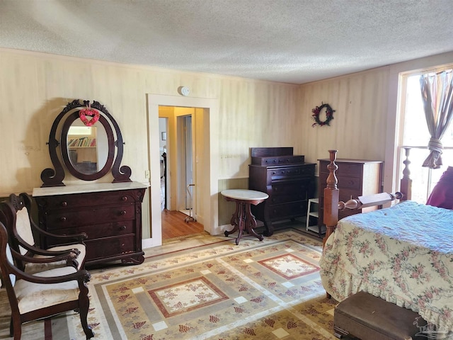 bedroom featuring light hardwood / wood-style floors and a textured ceiling