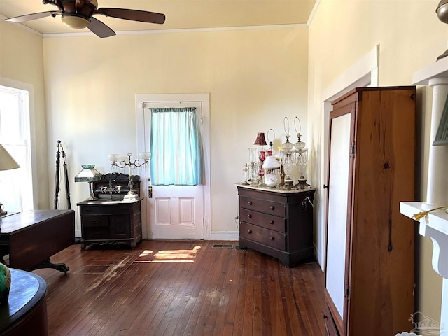 foyer entrance with crown molding, ceiling fan, and dark hardwood / wood-style flooring