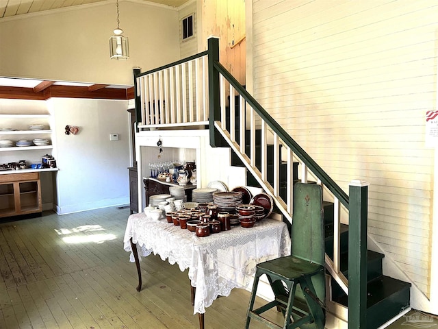 dining area with ornamental molding, wood-type flooring, and high vaulted ceiling