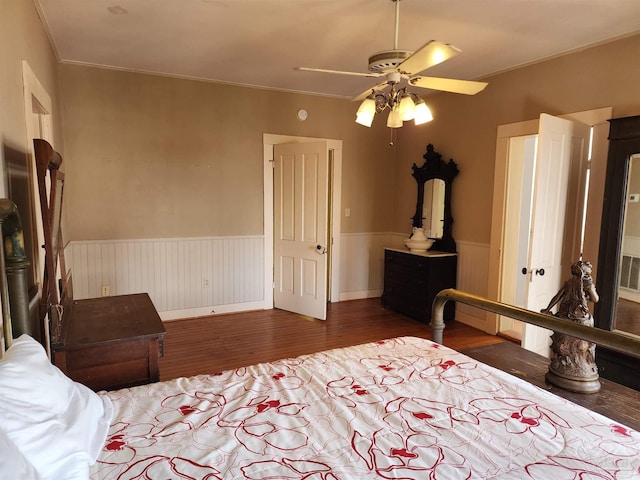 bedroom featuring dark wood-type flooring, ornamental molding, and ceiling fan