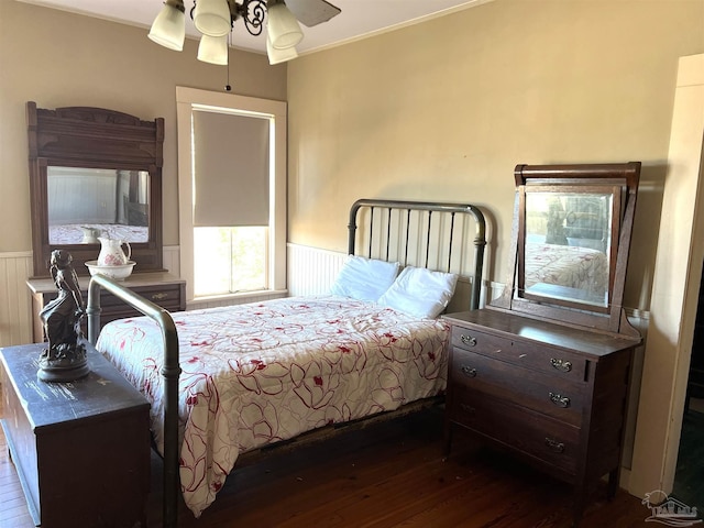 bedroom with ornamental molding, ceiling fan, and dark hardwood / wood-style flooring