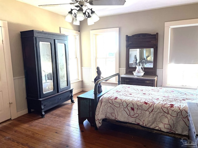 bedroom with hardwood / wood-style flooring, ceiling fan, and multiple windows