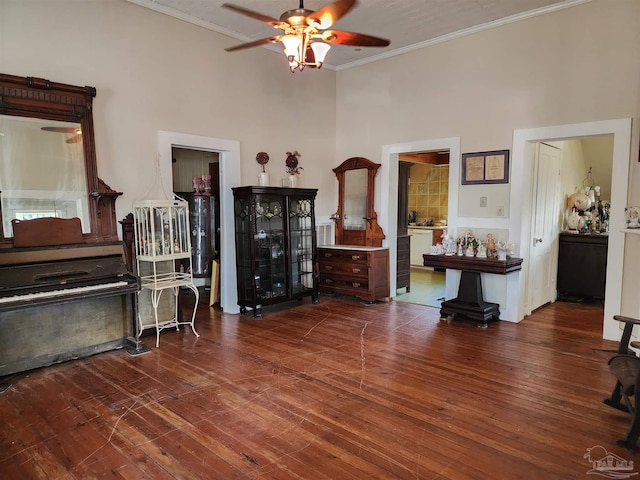 miscellaneous room with hardwood / wood-style flooring, crown molding, a towering ceiling, and ceiling fan