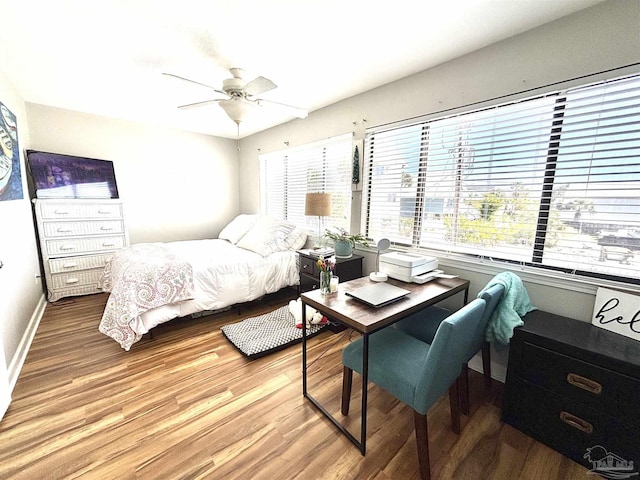 bedroom with light wood-style floors, a ceiling fan, and baseboards