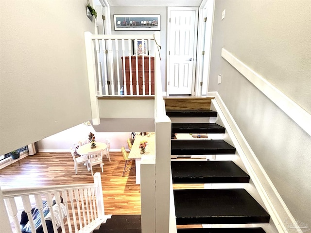 stairway with baseboards and wood finished floors