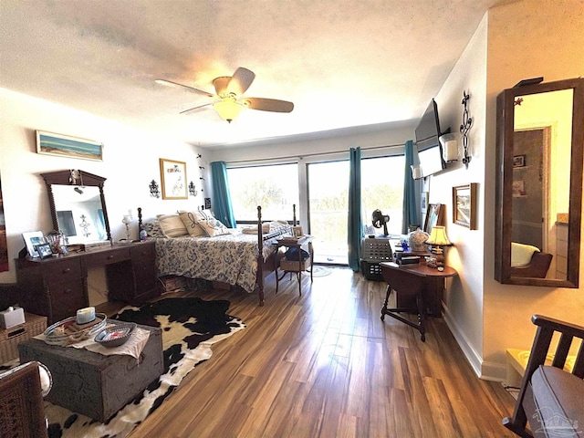 bedroom featuring baseboards, access to outside, a textured ceiling, and wood finished floors