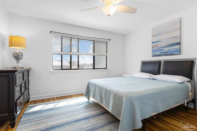 bedroom with baseboards, ceiling fan, and wood finished floors