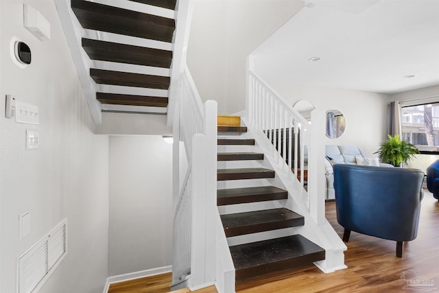 stairway featuring baseboards and wood finished floors