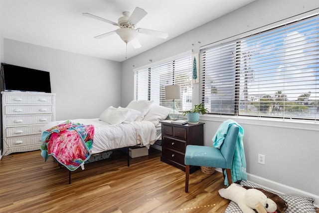 bedroom with baseboards, a ceiling fan, and wood finished floors