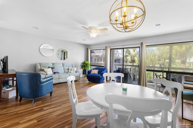 dining space featuring ceiling fan with notable chandelier, recessed lighting, and wood finished floors
