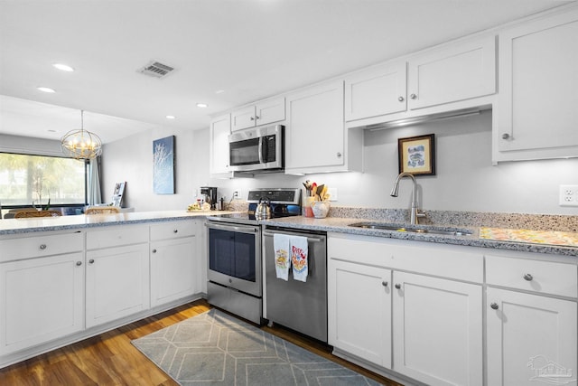 kitchen featuring visible vents, recessed lighting, white cabinets, a sink, and appliances with stainless steel finishes