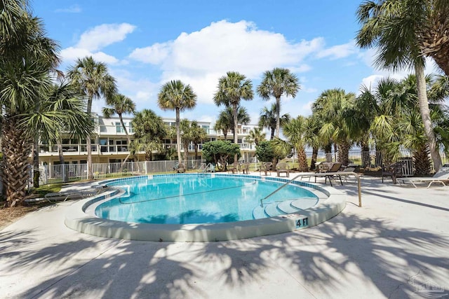 pool with fence and a patio area
