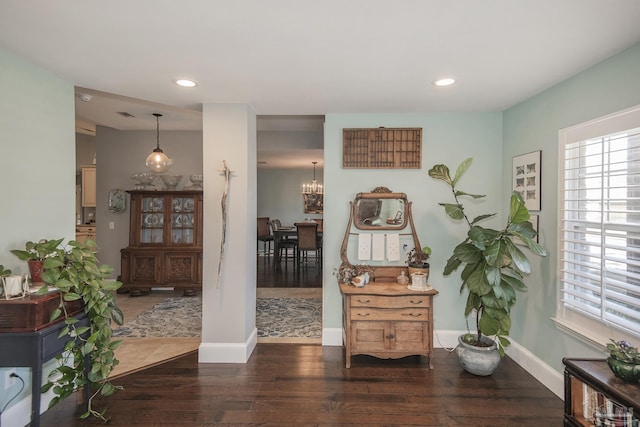 interior space featuring dark wood-type flooring and a chandelier