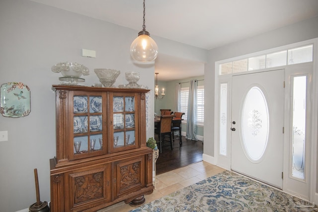 foyer entrance with a notable chandelier and light tile patterned flooring