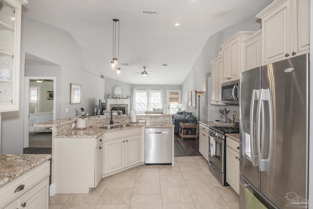 kitchen with decorative light fixtures, ceiling fan, lofted ceiling, sink, and appliances with stainless steel finishes