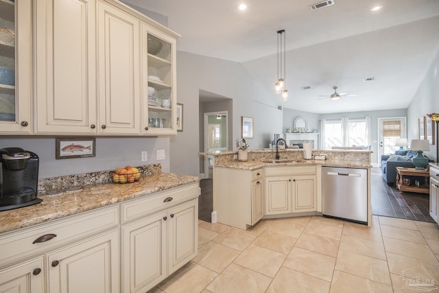 kitchen with decorative light fixtures, vaulted ceiling, stainless steel dishwasher, cream cabinets, and sink