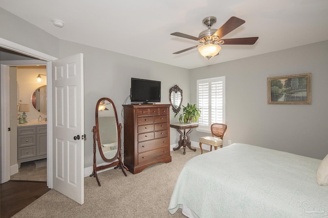 carpeted bedroom with ceiling fan, sink, and ensuite bathroom