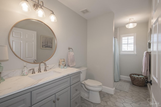 bathroom featuring toilet, an inviting chandelier, tile patterned floors, and vanity