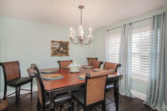 dining room featuring a healthy amount of sunlight, dark hardwood / wood-style flooring, and a chandelier