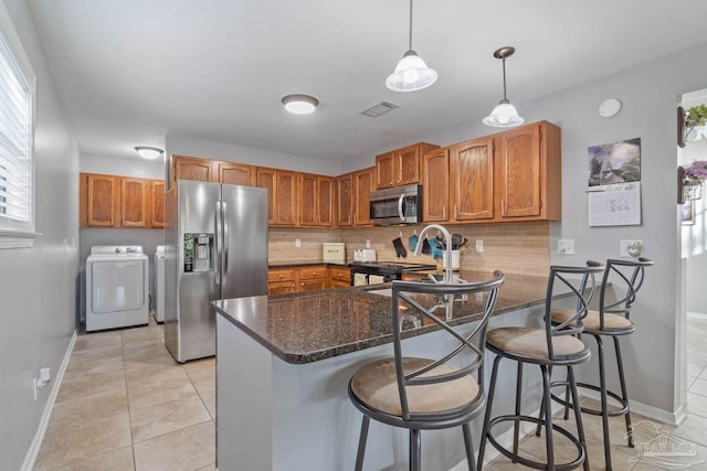 1841 E Smugglers Cove Dr, Gulf Breeze, FL 32563 - kitchen featuring stainless steel appliances, independent washer and dryer, baseboards, and tasteful backsplash