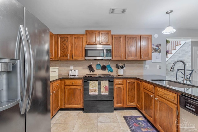 1841 E Smugglers Cove Dr, Gulf Breeze, FL 32563 - kitchen with appliances with stainless steel finishes, a sink, dark stone countertops, and brown cabinetry