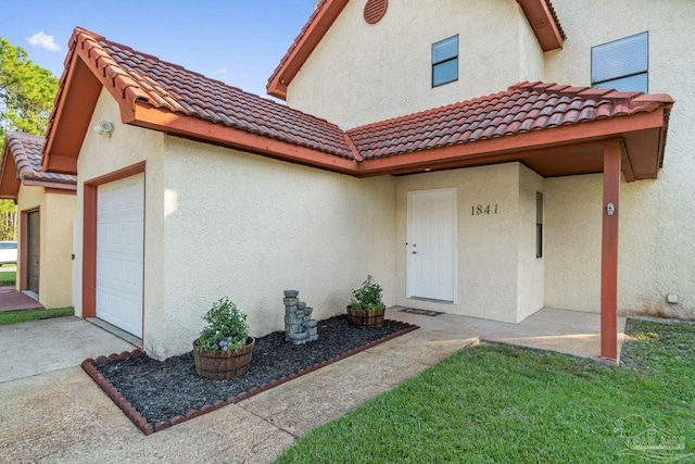 1841 E Smugglers Cove Dr, Gulf Breeze, FL 32563 - view of front of house featuring a tile roof, stucco siding, and a garage