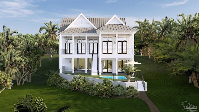 rear view of house with metal roof, a patio, a balcony, an outdoor pool, and a standing seam roof