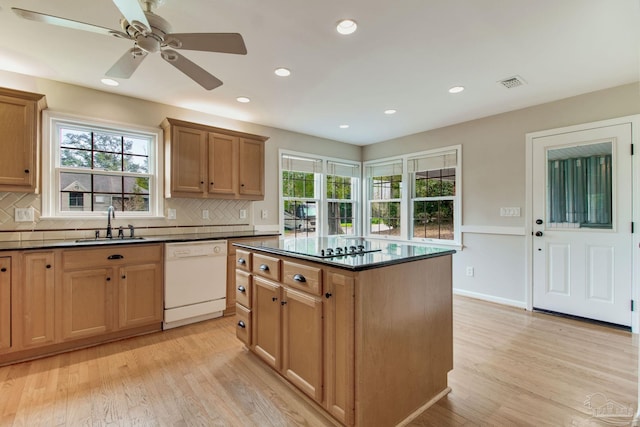 kitchen featuring dark countertops, a sink, visible vents, and dishwasher