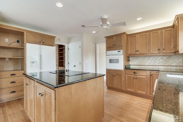 kitchen featuring white appliances, decorative backsplash, dark stone counters, open shelves, and light wood finished floors