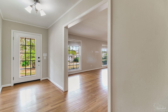 entrance foyer with light wood-style flooring, ornamental molding, and baseboards